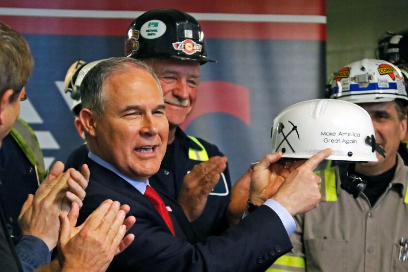 U.S. Environmental Protection Agency Administrator Scott Pruitt holds up a hardhat he was given during a visit to Consol Pennsylvania Coal Company's Harvey Mine in Sycamore, Pa., Thursday, April 13, 2017. (AP Photo/Gene J. Puskar)