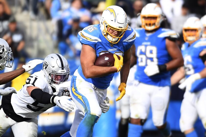 CARSON, CA - DECEMBER 22: Tight end Hunter Henry #86 of the Los Angeles Chargers breaks tackles as he rush after catching a pass against inside linebacker Will Compton #51 and cornerback Trayvon Mullen #27 of the Oakland Raiders bring the first half at Dignity Health Sports Park on December 22, 2019 in Carson, California. (Photo by Kevork Djansezian/Getty Images)