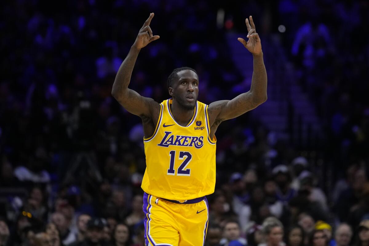 Lakers forward Taurean Prince raises both hands above his head to signify a made three-pointer during a game in Philadelphia.