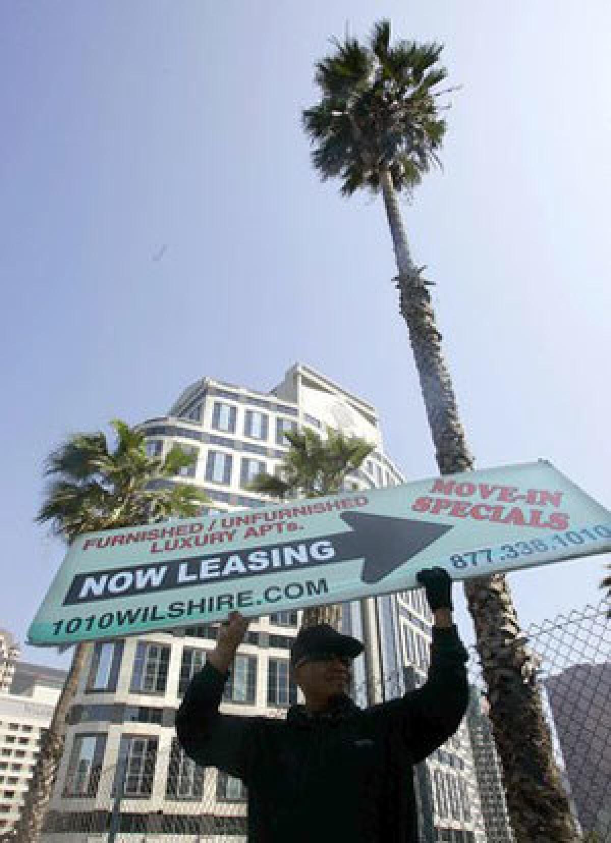 Sign twirler Santos Pastor advertises apartments on Wilshire Boulevard in downtown Los Angeles.