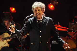 A man with curly gray hair sings onstage