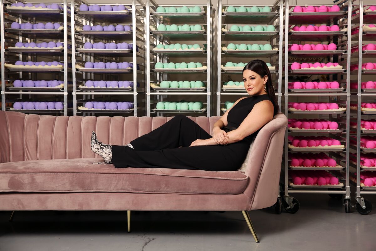 Olivia Alexander, founder and chief executive of Kush Queen, at the company's headquarters in Anaheim, framed by racks of bath bombs infused with CBD.