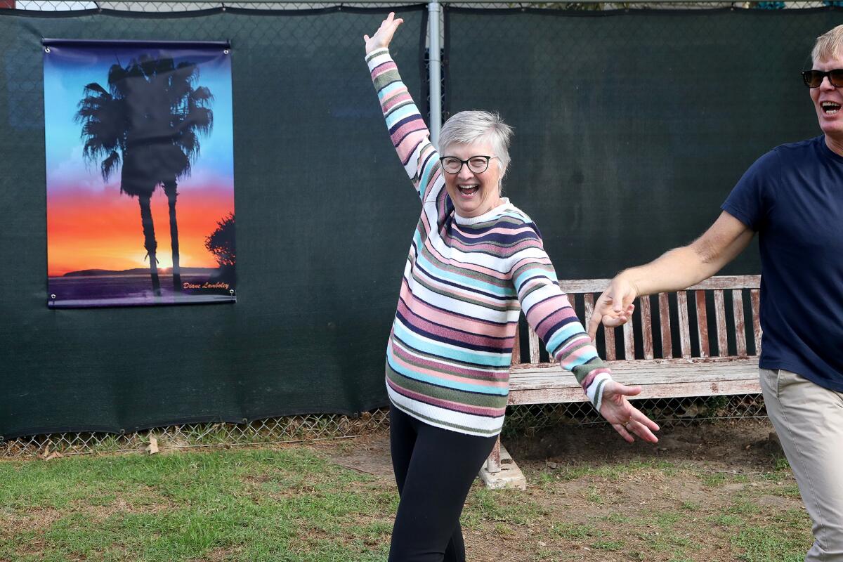 Diane Lamboley poses in front of her photograph, the first art piece as part of an art gallery at the Laguna Beach Dog Park.