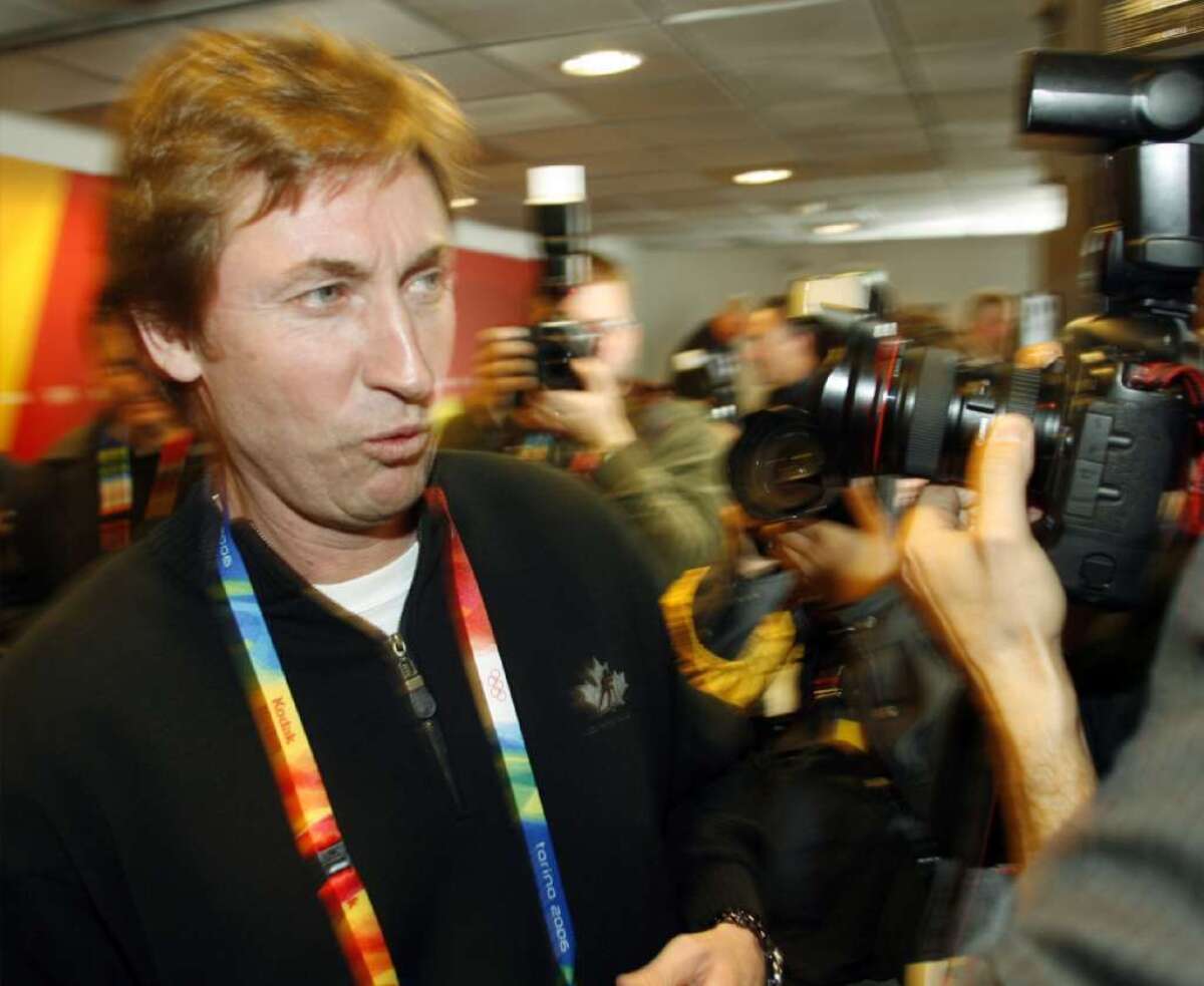 Wayne Gretzky makes his way through a crush of photographers after a news conference at the 2006 Winter Olympics in Turin.