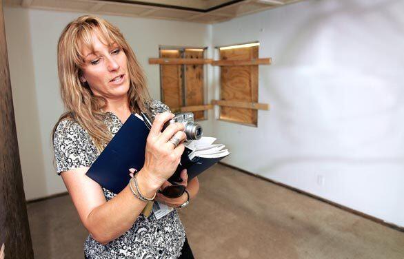 Redevelopment Project Coordinator Lisa Russo photographs the interior of a home that the city of Lancaster has purchased in the Piute neighborhood. Russo is responsible for planning and contracting the improvements to each house purchased as part of the citys Neighborhood Preservation Home Ownership Program.