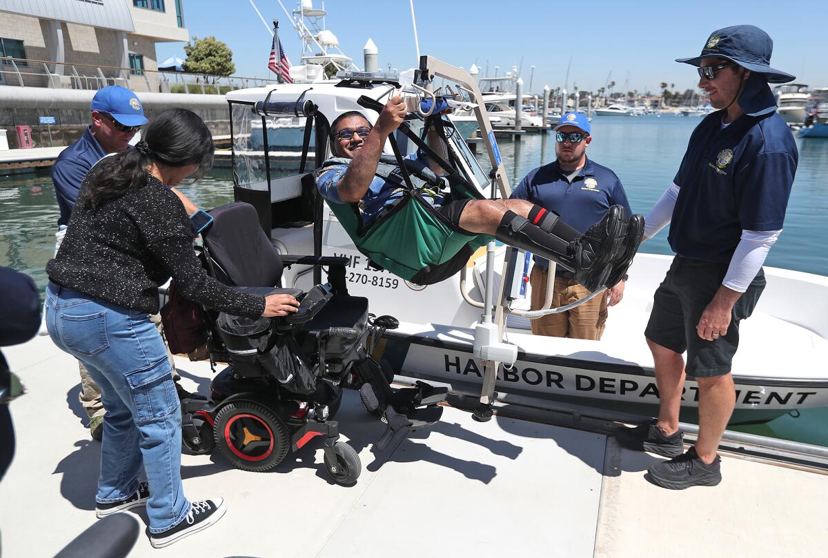 Bhumit Shah, a disabled boater, is lifted onto a power boat.