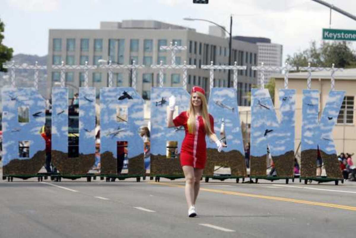 Krystal Keables waves to onlookers as she marches in Burbank on Parade, which took place on Olive Avenue between Keystone Street and Lomita Street on Saturday.