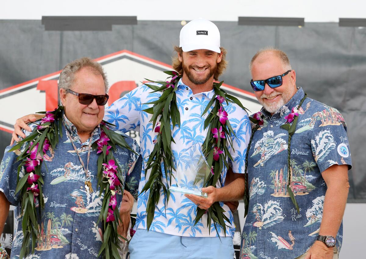 Inductee Brett Simpson, a two-time U.S. Open of Surfing champion, poses with Peter Townend, left, and John Etheridge.
