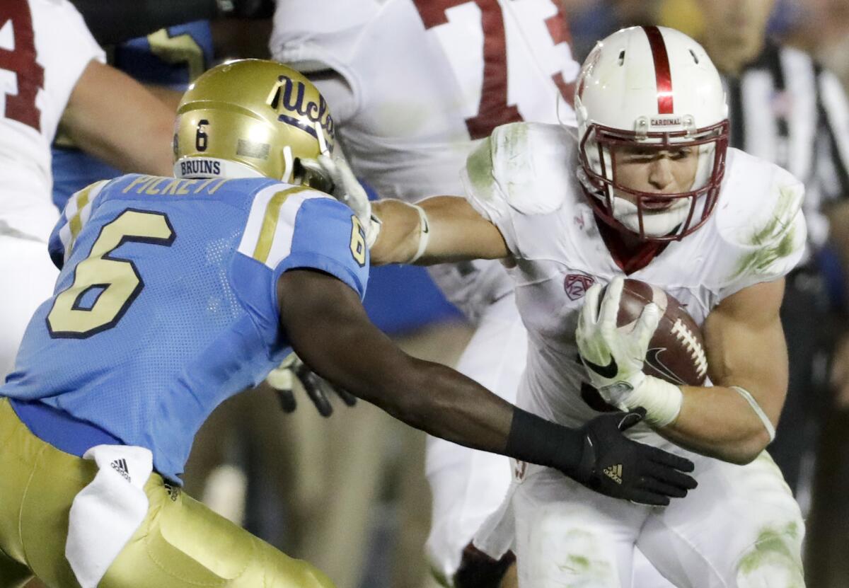 Stanford's Christian McCaffrey runs around UCLA's Adarius Pickett on Sept. 24.