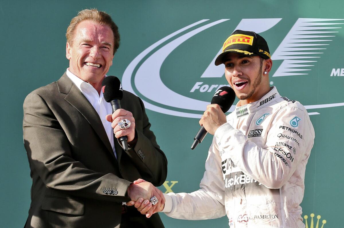 Formula One driver Lewis Hamilton, right, is congratulated by Arnold Schwarzenegger after winning the Australian Grand Prix on Sunday.