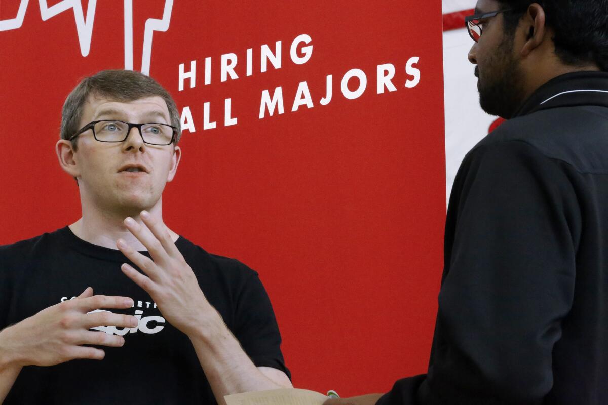 Jacob Robinson, left, of Epic, an electronic health record software company, speaks with students attending The Foot in the Door Career Fair at the University of Illinois in Springfield, Ill. Job openings were the highest in 14 years, Labor Department said.