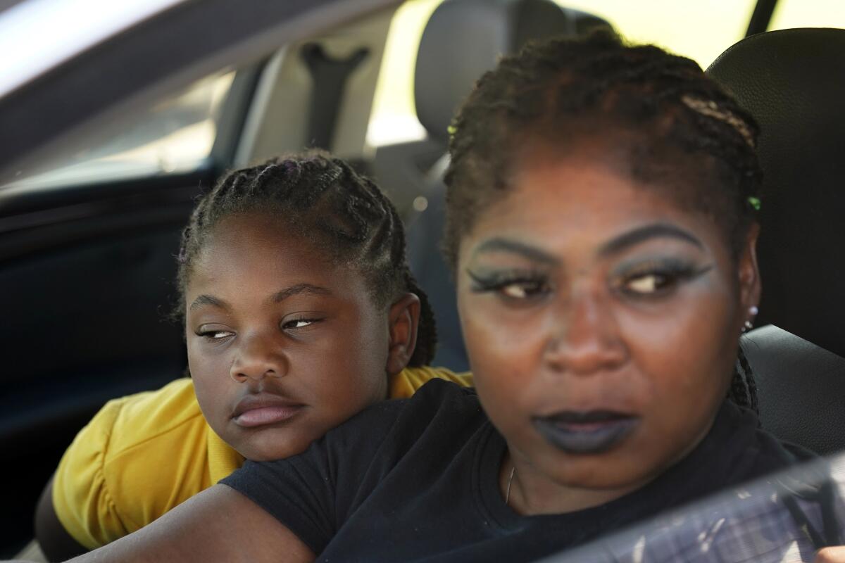 Mitoya Wilson sits in her car with her daughter Charleigh Wilson, 8, as she talks about the history of troubles with the town drinking water, in Ferriday, La., Tuesday, Sept. 13, 2022. In many places, people struggle to find water or else drink water that isn't clean. (AP Photo/Gerald Herbert)
