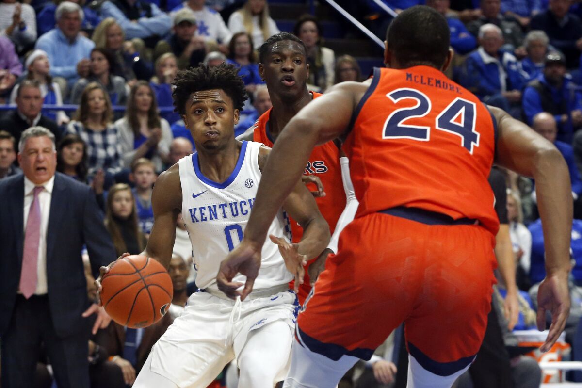 Kentucky's Ashton Hagans, left, looks for an opening against Auburn's Anfernee McLemore (24) during the first half of an NCAA college basketball game in Lexington, Ky., Saturday, Feb. 29, 2020. (AP Photo/James Crisp)