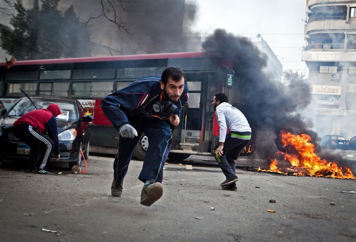 Supporters of Egypt's deposed President Mohamed Morsi run for cover from tear gas fired by riot police during clashes in the northeastern part of Cairo's Nasr City district on Friday.