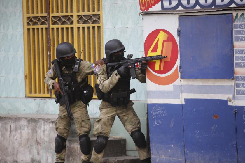 Policías se resguardan durante un operativo antipandillas en el vecindario Portail el jueves 29 de febrero de 2024, en Puerto Príncipe, Haití. (AP Foto/Odelyn Joseph)