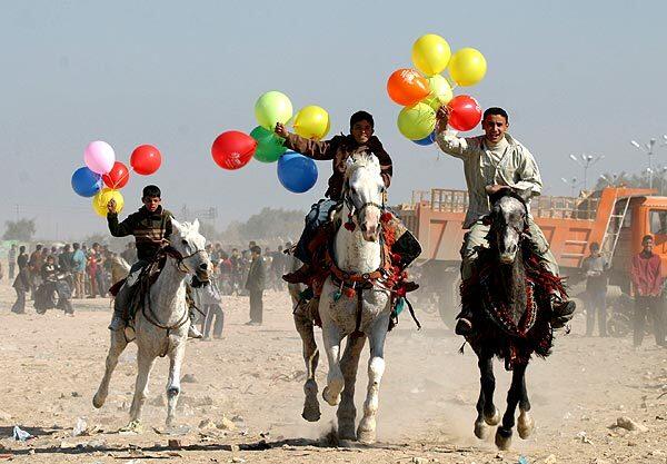 Iraqi boys trail balloons as they ride horses during celebrations for Eid al-Adha in the Shiite holy city of Najaf, about 100 miles south of Baghdad. Eid al-Adha, or the Feast of the Sacrifice, is celebrated by all Muslim sects and commemorates the prophet Abraham's faith and willingness to sacrifice his son for God.