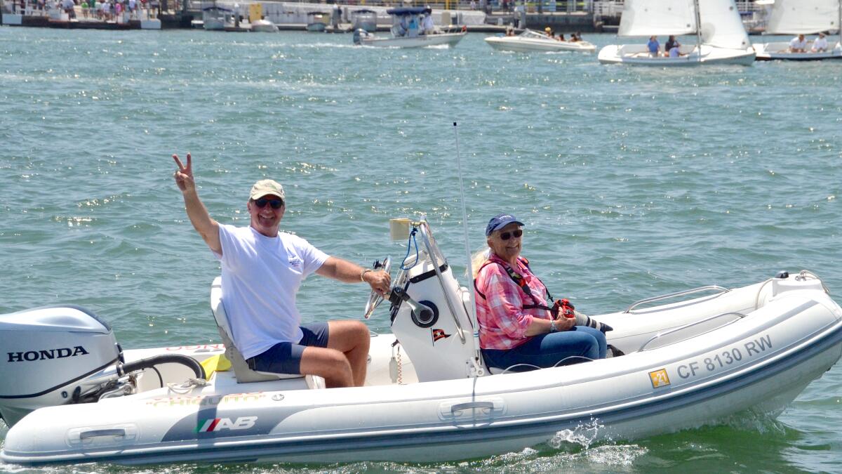 Flight of Newport Beach race chairman David Beek keeps watch on the Sunday race from his boat. With him is Bronny Daniels.