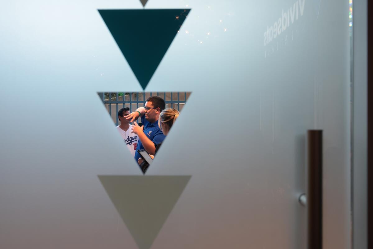 Dodger fans can be seen through a door window at the speakeasy under the Right Field Pavilion at Dodgers Stadium.