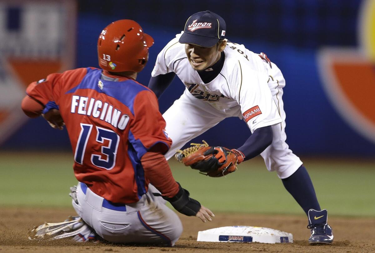 Japan's Takashi Toritani, right, waits to tag out Puerto Rico's Jesus Feliciano trying to steal second base during the fifth inning of a semifinal game of the World Baseball Classic in San Francisco, Sunday, March 17, 2013.