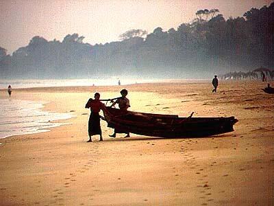 On an early morning near Ngapali Beach's southern end, commercial fishermen haul their boat down to the waterside.