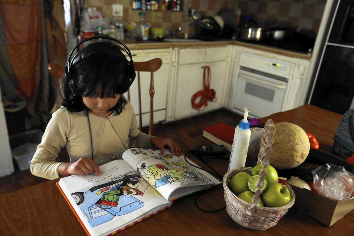 Alessandra Alamilla, 7, reads at the kitchen table in her home in San Bernardino. All of her siblings are focused on academics, and they all want to help their hardworking parents.