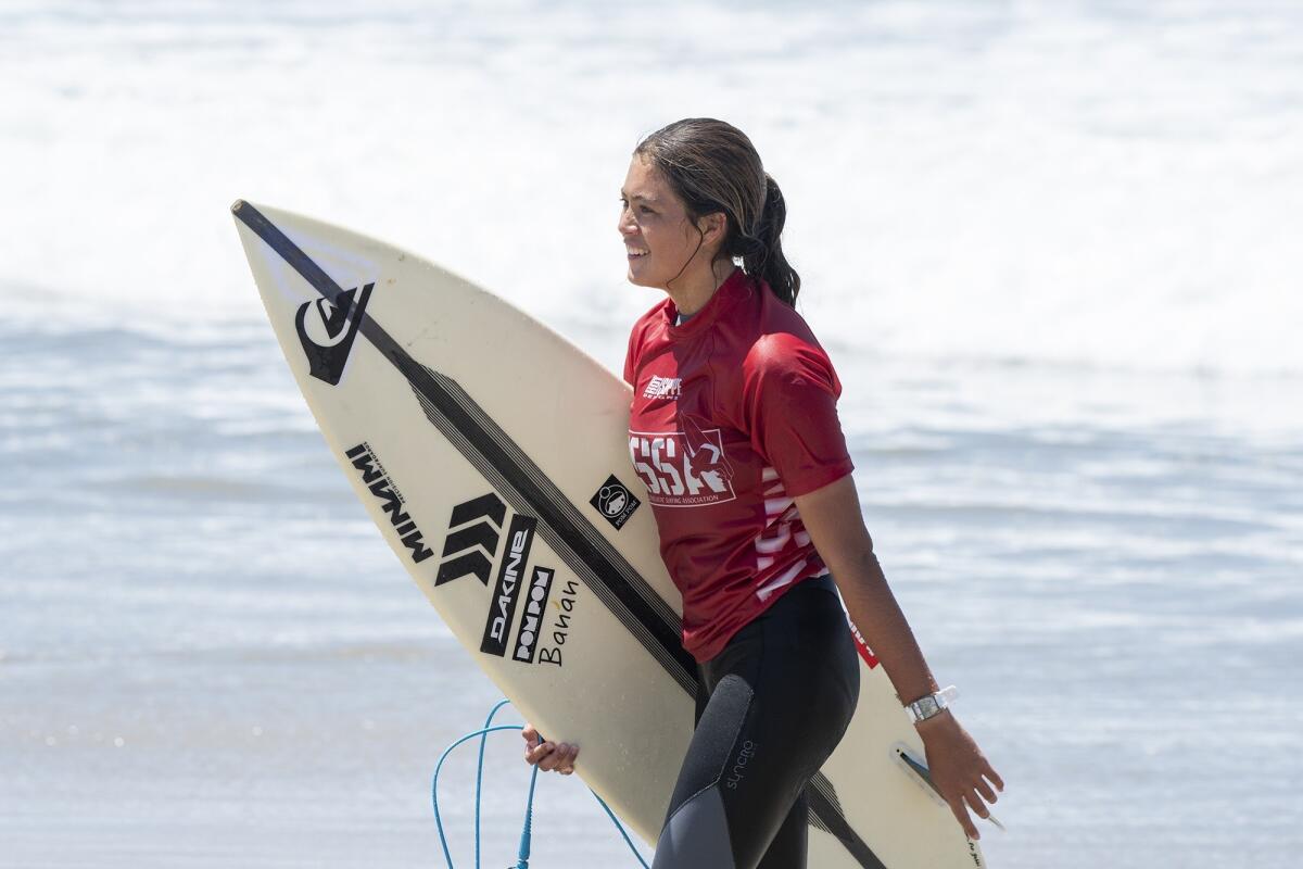 Gabbie Knudsen of Hawaii smiles to onlookers after competing in the women's open semifinals of the National Scholastic Surfing Assn. National Championships on Tuesday in Huntington Beach.