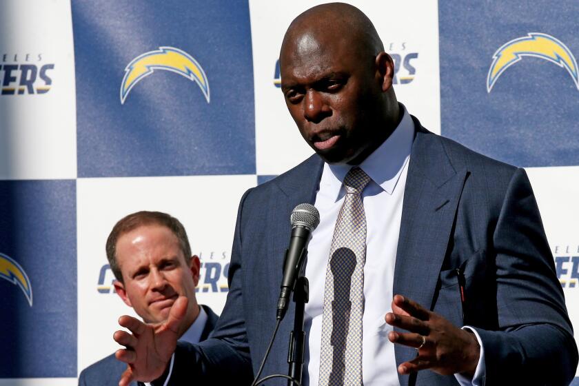 New Chargers Coach Anthony Lynn, right, talks with reporters during a news conference to announce his hiring on Jan. 17 at StubHub Center in Carson.