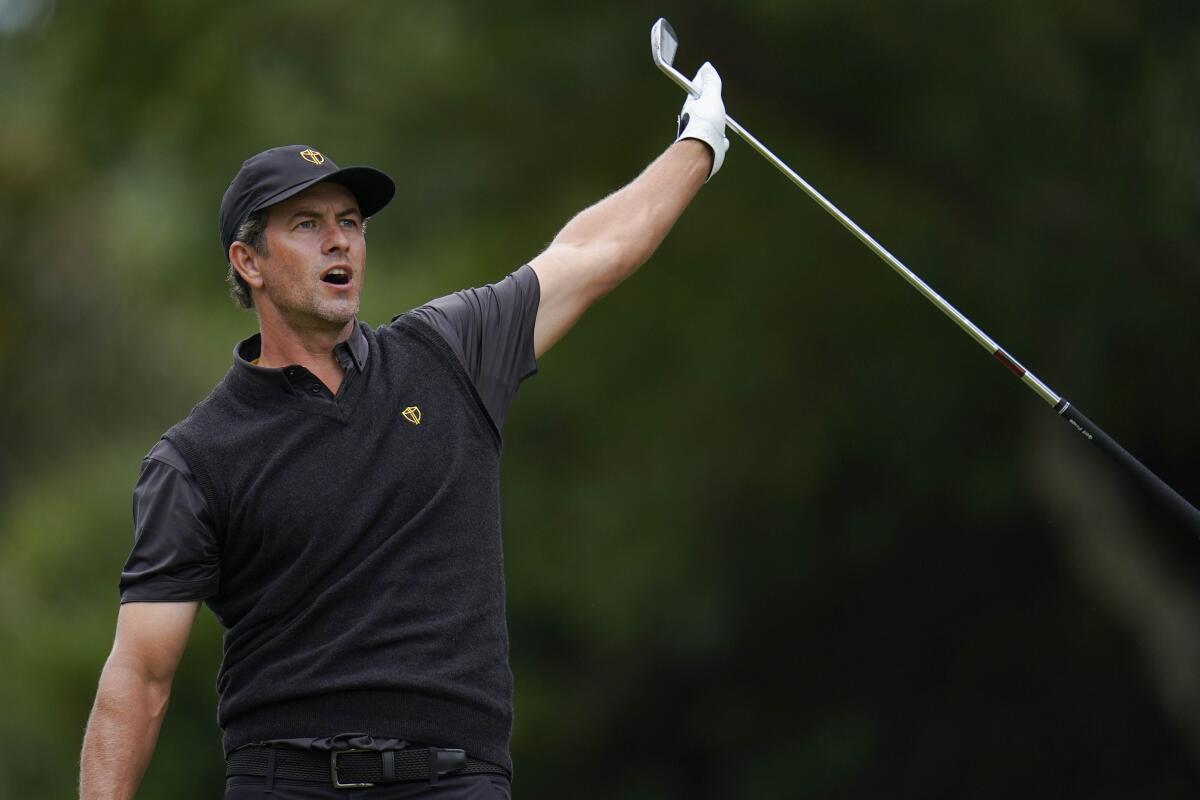 Adam Scott, of Australia, reacts to his ball's flight off the sixth tee during their singles match at the Presidents Cup golf tournament at the Quail Hollow Club, Sunday, Sept. 25, 2022, in Charlotte, N.C. (AP Photo/Julio Cortez)