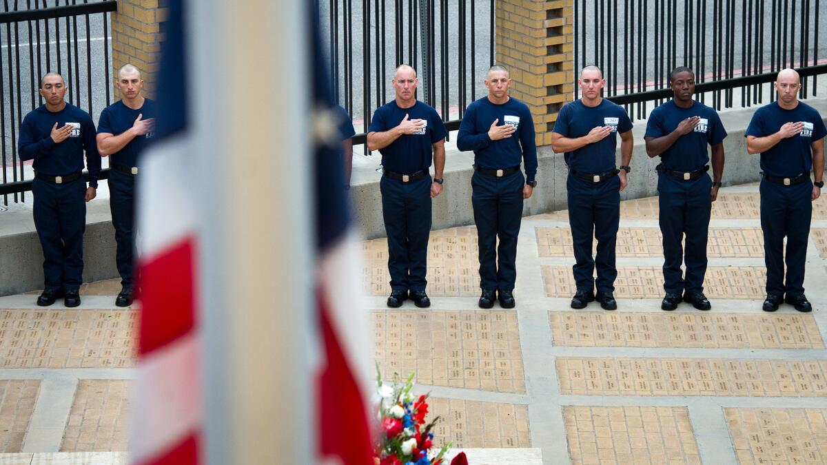 Los Angeles Fire Department cadets pay honors as the American flag is lowered to half-staff at a 9/11 ceremony at the LAFD Historical Society Museum and Fallen Firefighters Memorial at Fire Station 27.