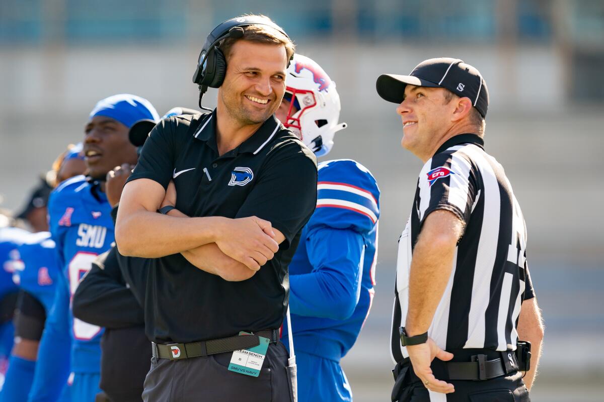 Southern Methodist offensive coordinator Casey Woods talks with referee Keegan Ashbee along the sideline.