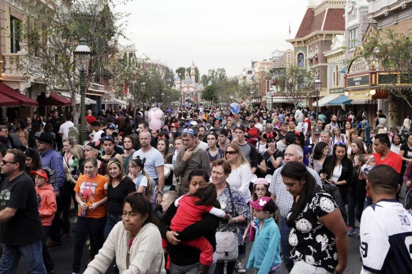 FILE - In this Jan. 22, 2015, file photo, people crowd Main Street at Disneyland in Anaheim, Calif. California health officials have declared an end to the large measles outbreak that originated at Disneyland in December. (AP Photo/Jae C. Hong, File) ORG XMIT: LA102