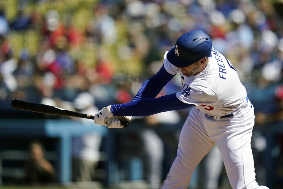 Freddie Freeman hits a run-scoring double for the Dodgers against the Cardinals on Sunday.