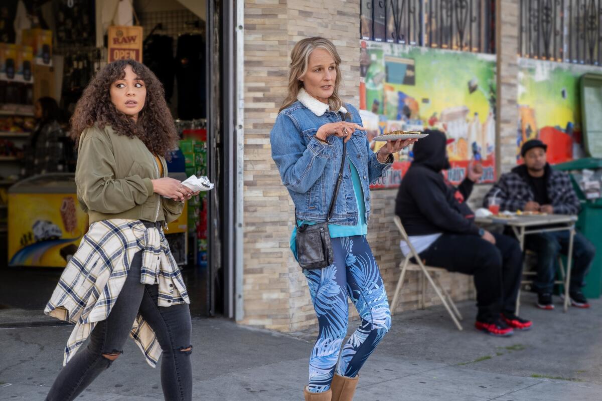 Two women talking on the sidewalk outside an Oakland eatery