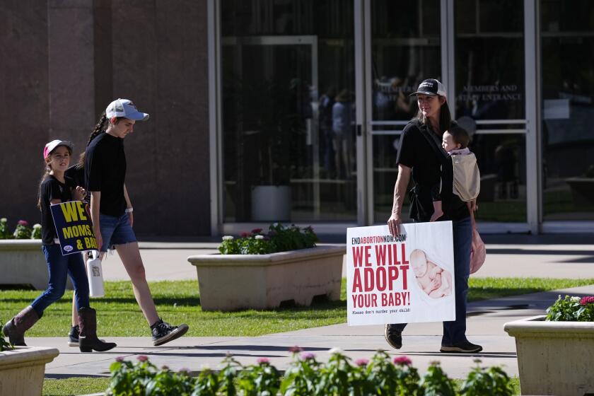 FILE - Pro-life demonstrators walk in the front of the Arizona Capitol prior to the vote on the proposed repeal of the state's near-total ban on abortions prior to winning approval from the state House on, April 24, 2024, in Phoenix. Democrats at the Arizona Legislature are expected to make a final push Wednesday, May 1, to repeal the state’s long-dormant ban on nearly all abortions that a court said can be enforced. (AP Photo/Ross D. Franklin, File)