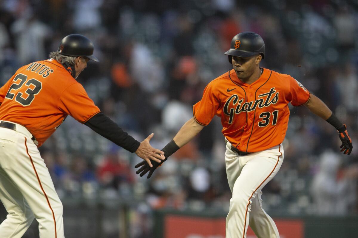 San Francisco Giants' LaMonte Wade Jr. (31) gets a congratulatory handshake from third base coach Ron Wotus (23) after hitting a solo home run against the Chicago Cubs during the fourth inning of a baseball game, Friday, June 4, 2021, in San Francisco. (AP Photo/D. Ross Cameron)