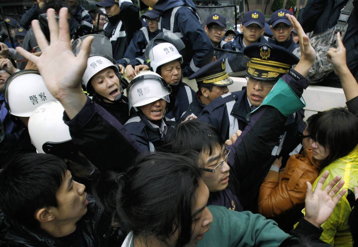 Demonstrators protesting the proposed sale of Next Media group in Taiwan scuffle with police in Taipei, the capital.