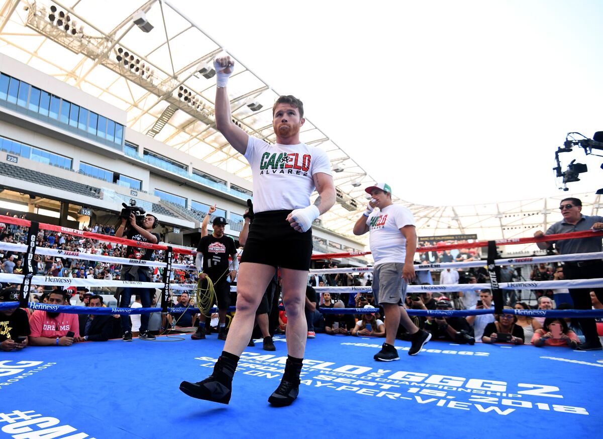 Canelo Alvarez waves to fans during a media workout at Banc of California Stadium on Aug. 26, 2018.