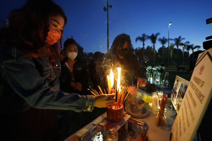 Women pay theirs respects at a memorial in honor of the victims of the shootings in Atlanta, where eight people were killed the week before, during a candle vigil in Monterrey Park, Calif., late Saturday, March 27, 2021. The shootings at three Georgia massage parlors and spas that left eight people dead, six of them women of Asian descent, come on the heels of a recent wave of attacks against Asian Americans since the coronavirus entered the United States. (AP Photo/Damian Dovarganes)