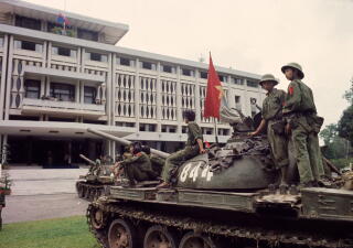Victorious North Vietnamese troops on tanks take up positions outside Indep