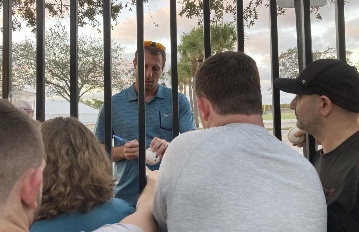 New York Mets pitcher Max Scherzer signs autographs for fans following a baseball labor negotiating session.