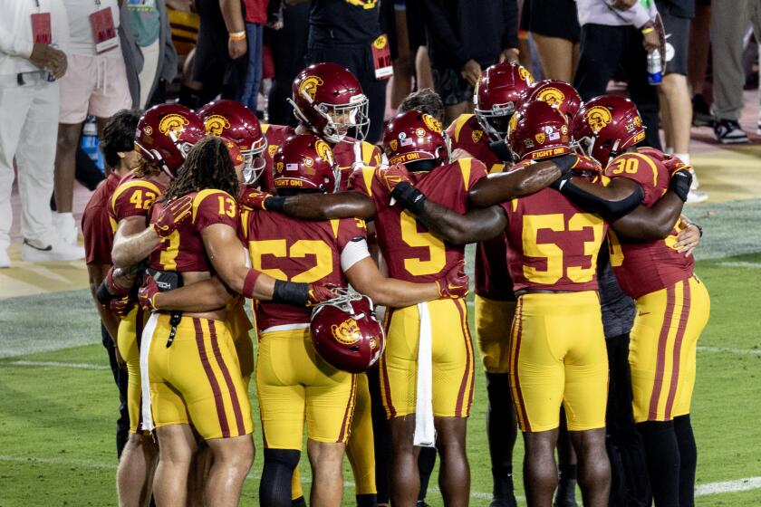 The USC defense huddles together on the field before playing Arizona at the Coliseum on Oct. 7.