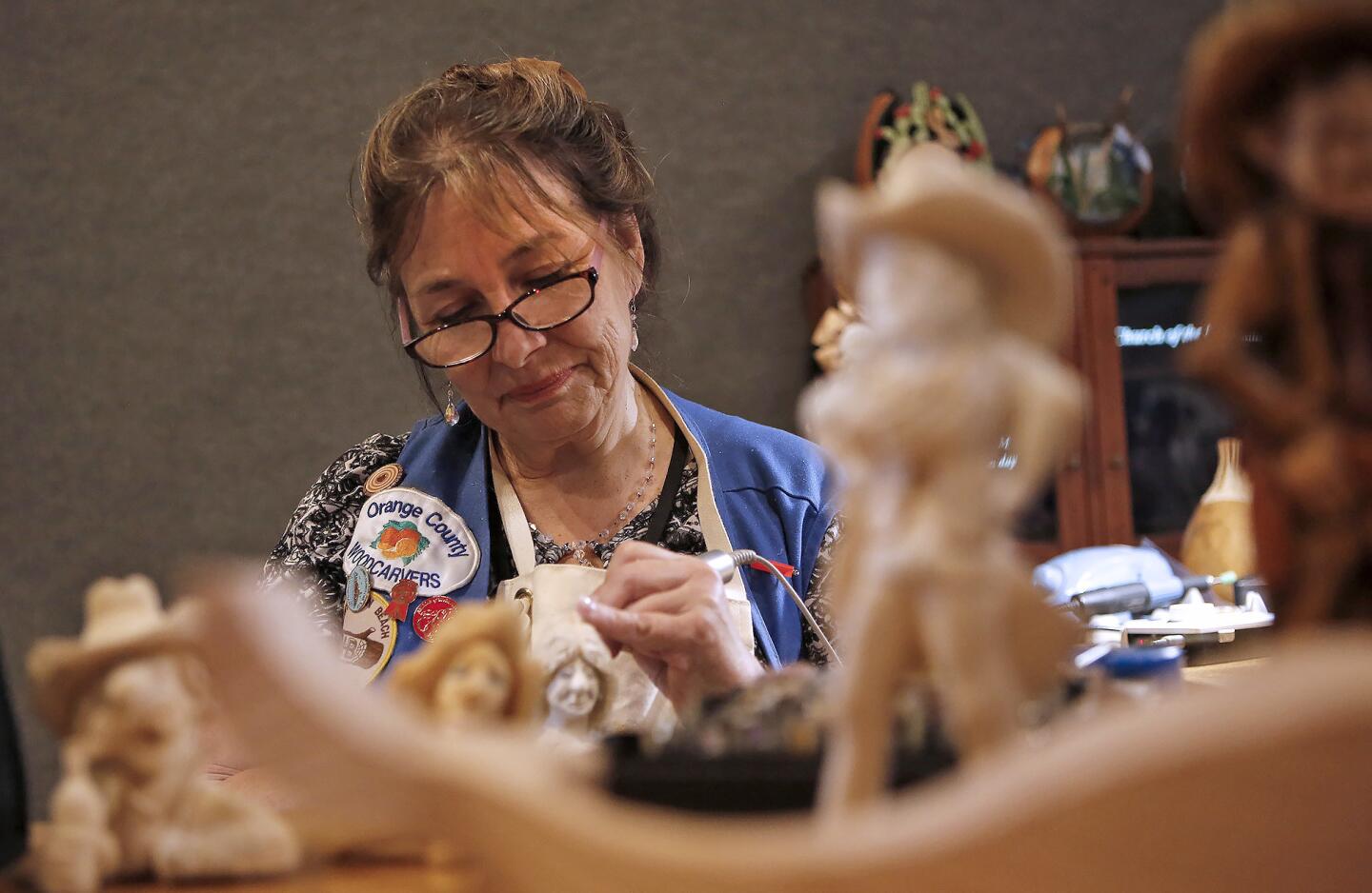 Linda Conn carves cowboy figurines out of basswood at the California Carvers Guild demonstration table at the Orange County Fair in Costa Mesa. Orange County Woodcarvers is a chapter of the carvers guild.