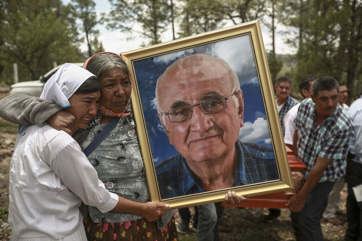 Mujeres cargan un retrato del sacerdote jesuita Javier Campos Morales en su cortejo fúnebre