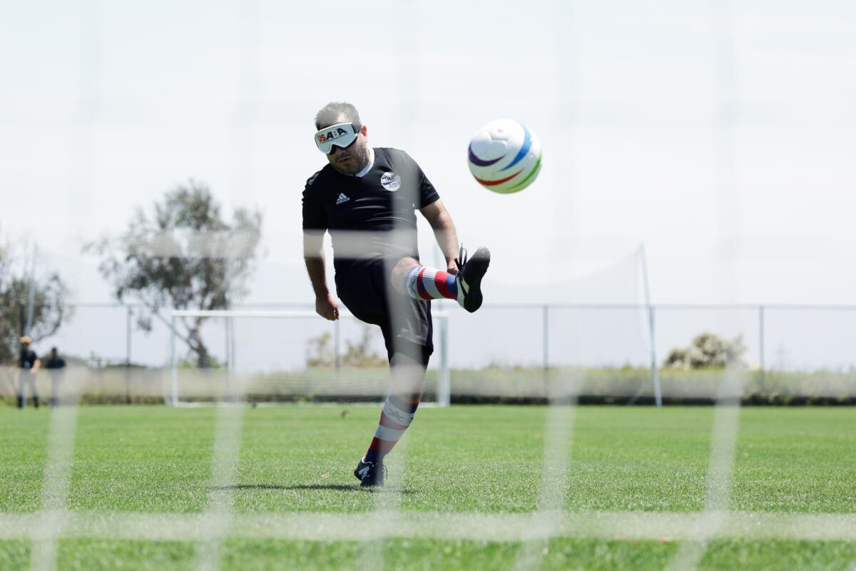 A photograph of a parathlete soccer player kicking a ball.