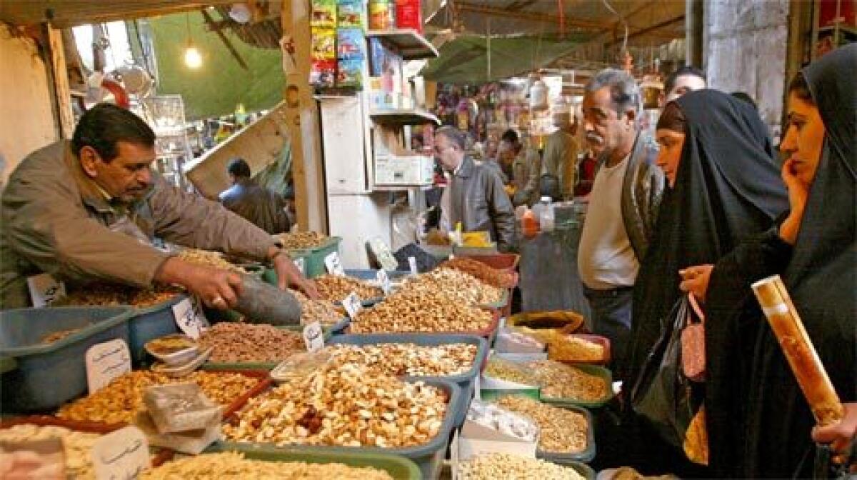 IN BAGHDAD: Iraqis purchase nuts at a market before Eid al-Adha festivities that commemorate the prophet Abrahams willingness to sacrifice his son for God. Sunnis in many Iraqi cities say the security gains have allowed them to fully celebrate the holiday.