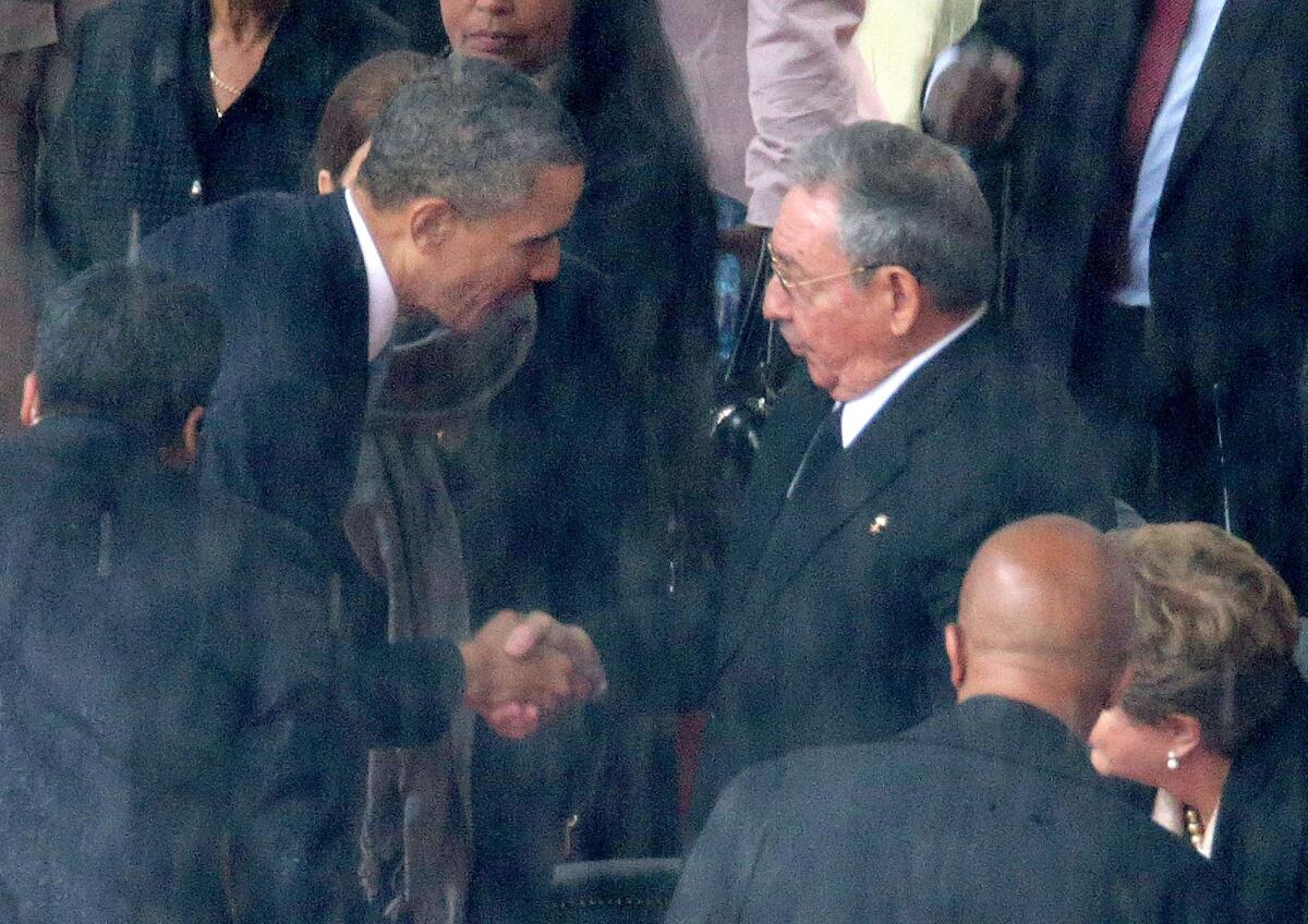 President Obama, left, shakes hands with Cuban President Raul Castro during the official memorial service for former South African President Nelson Mandela at FNB Stadium in Johannesburg.