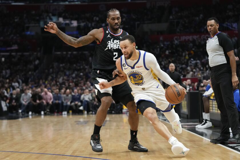Golden State Warriors' Stephen Curry (30) drives past Los Angeles Clippers' Kawhi Leonard (2) during the second half of an NBA basketball game Wednesday, March 15, 2023, in Los Angeles. The Clippers won 134-126. (AP Photo/Jae C. Hong)