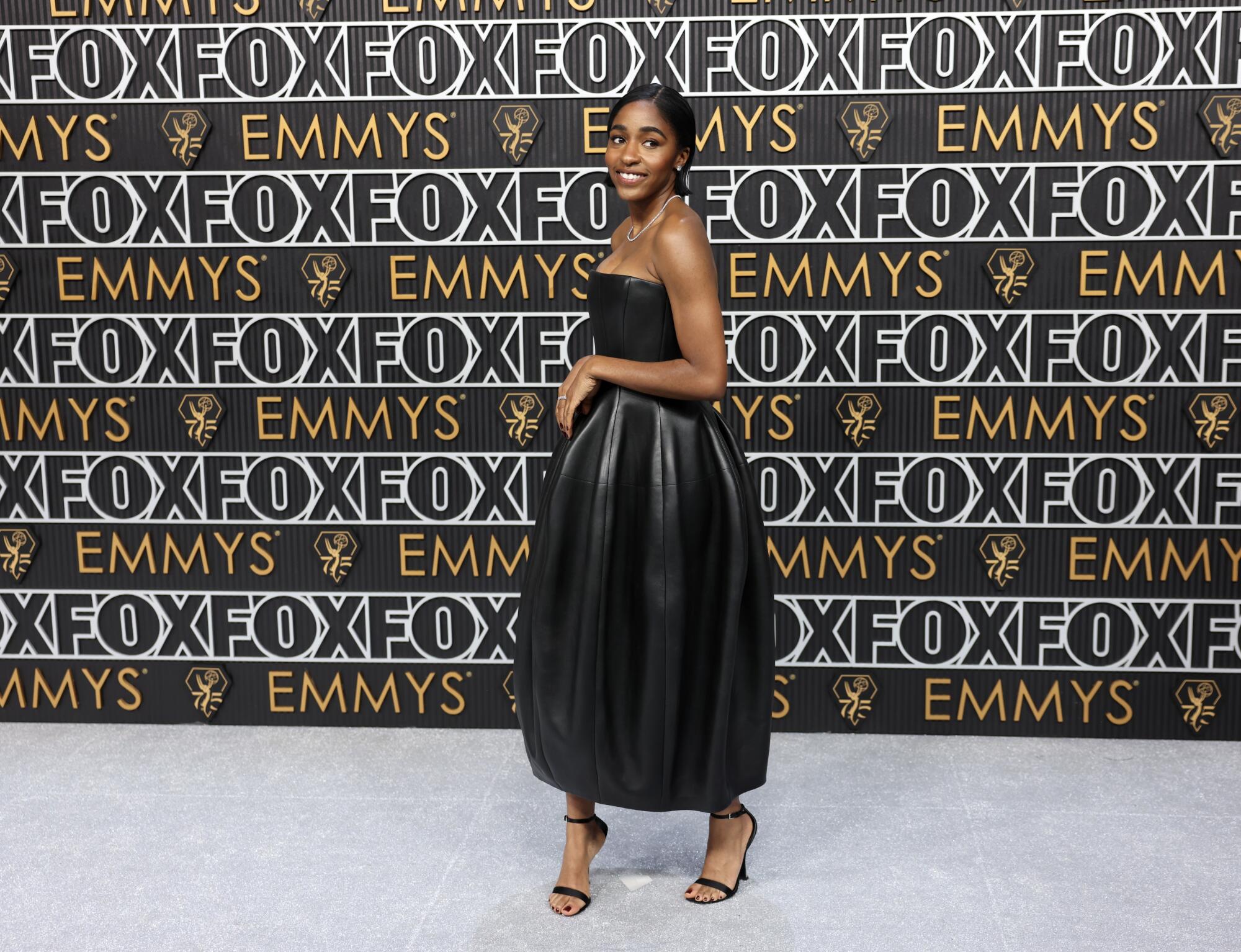 Ayo Edebiri wears a black dress on the Emmys red carpet. 