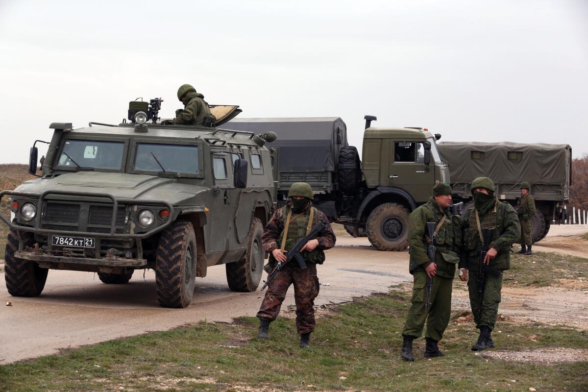 Russian-speaking troops in unmarked uniforms stand guard at the airport of Belbek, which they captured from the Ukrainian army. The Tigr combat vehicle in the photo has Russian army license plates.