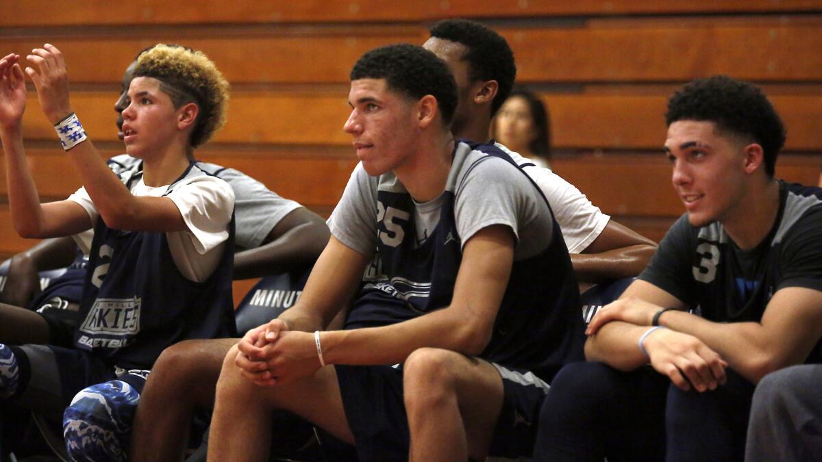 Brothers LaMelo, Lonzo and LiAngelo Ball (from left) watch Chino Hills teammates play against Muir during a game last summer.